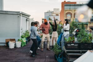 Social gathering of a group of friends on a rooftop in NYC. Bushwick, Brooklyn. They are dancing and having fun together.