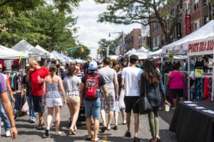 Astoria, New York, USA - 29 July 2018: Many people walking down the street looking to purchase goods from the vendors at a Queens street fair.